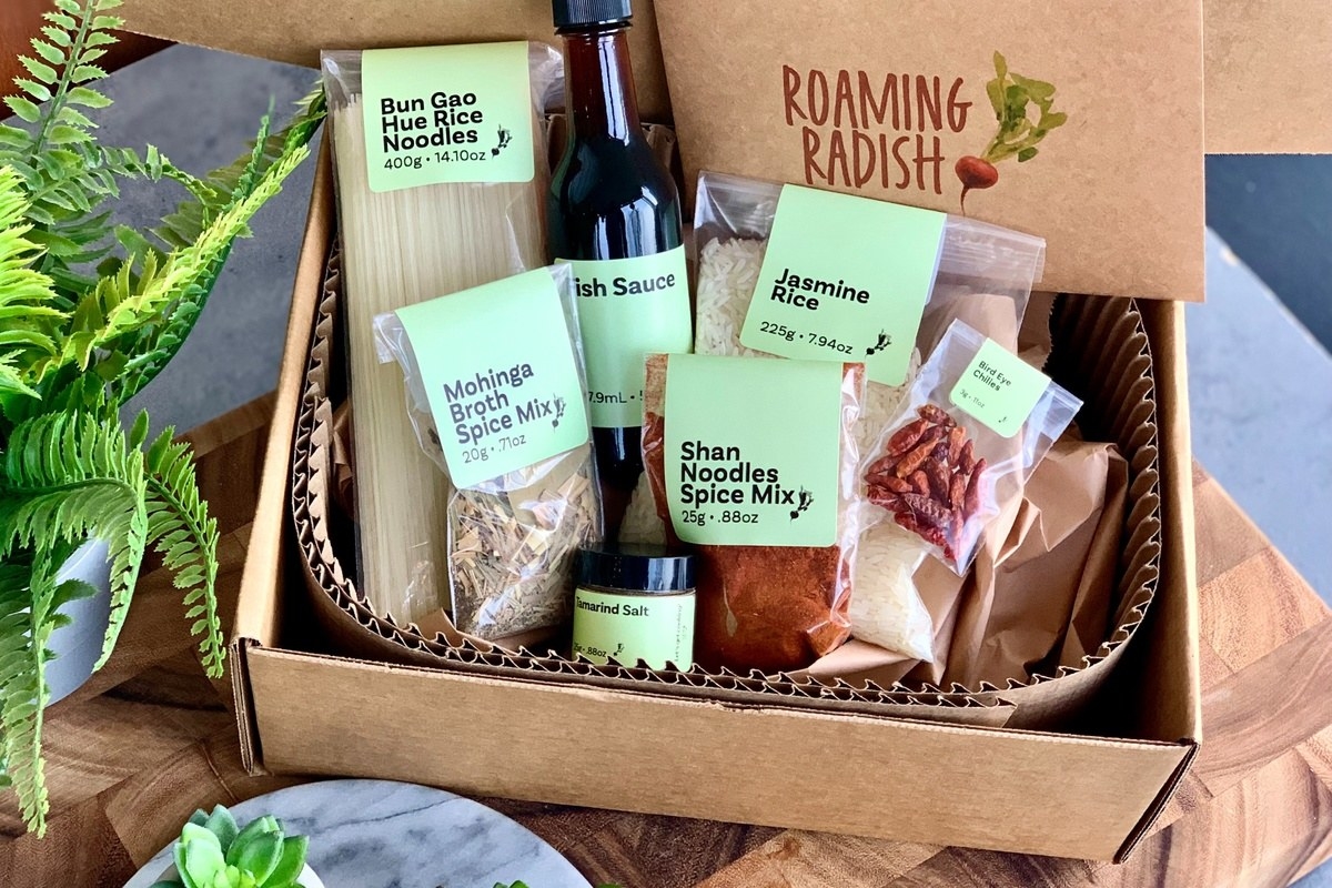 Cardboard box with noodles, spices, and sauces that reads &quot;Roaming Radish&quot;