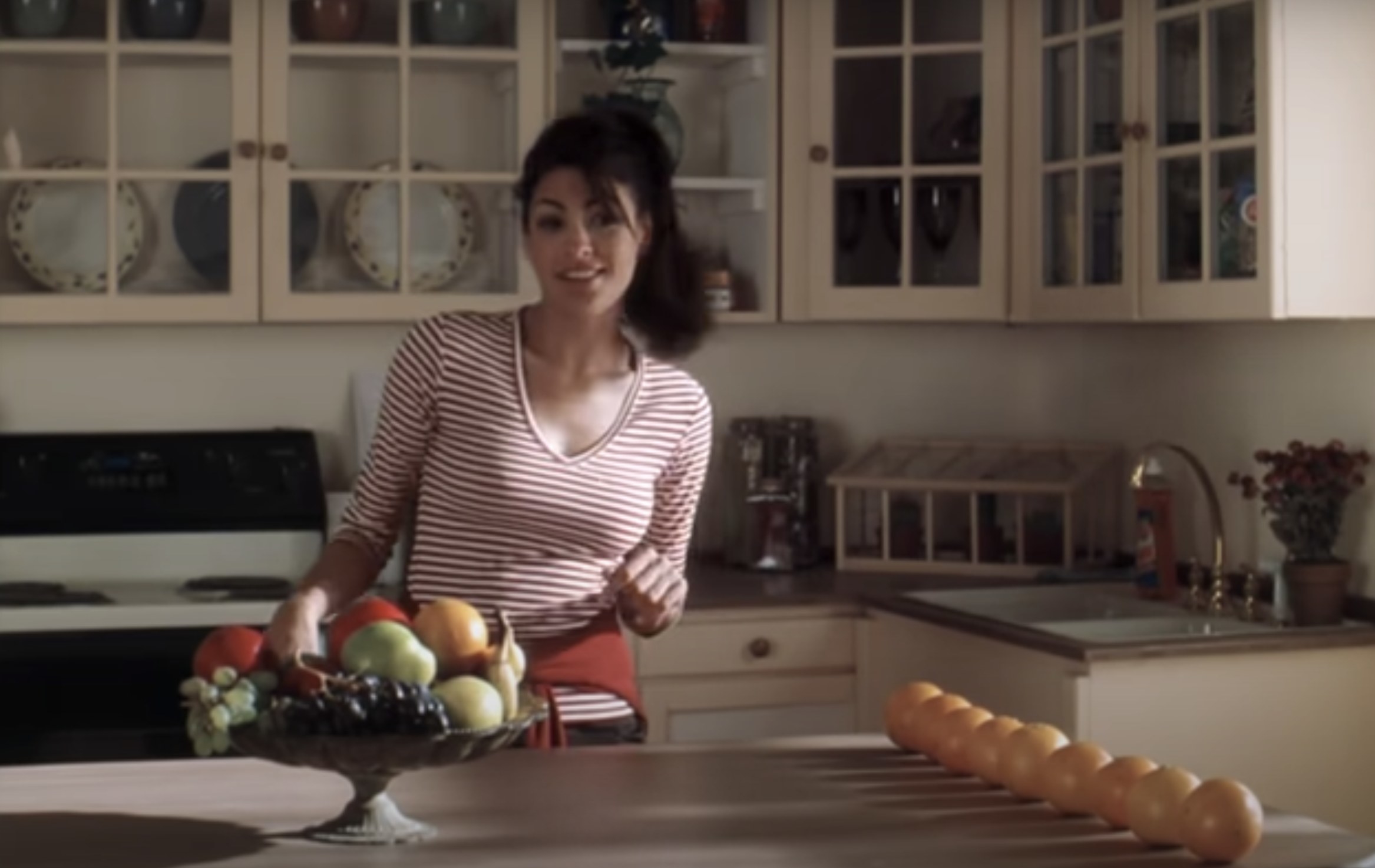 A young Eva smiles and stands in a kitchen in a clip from the film