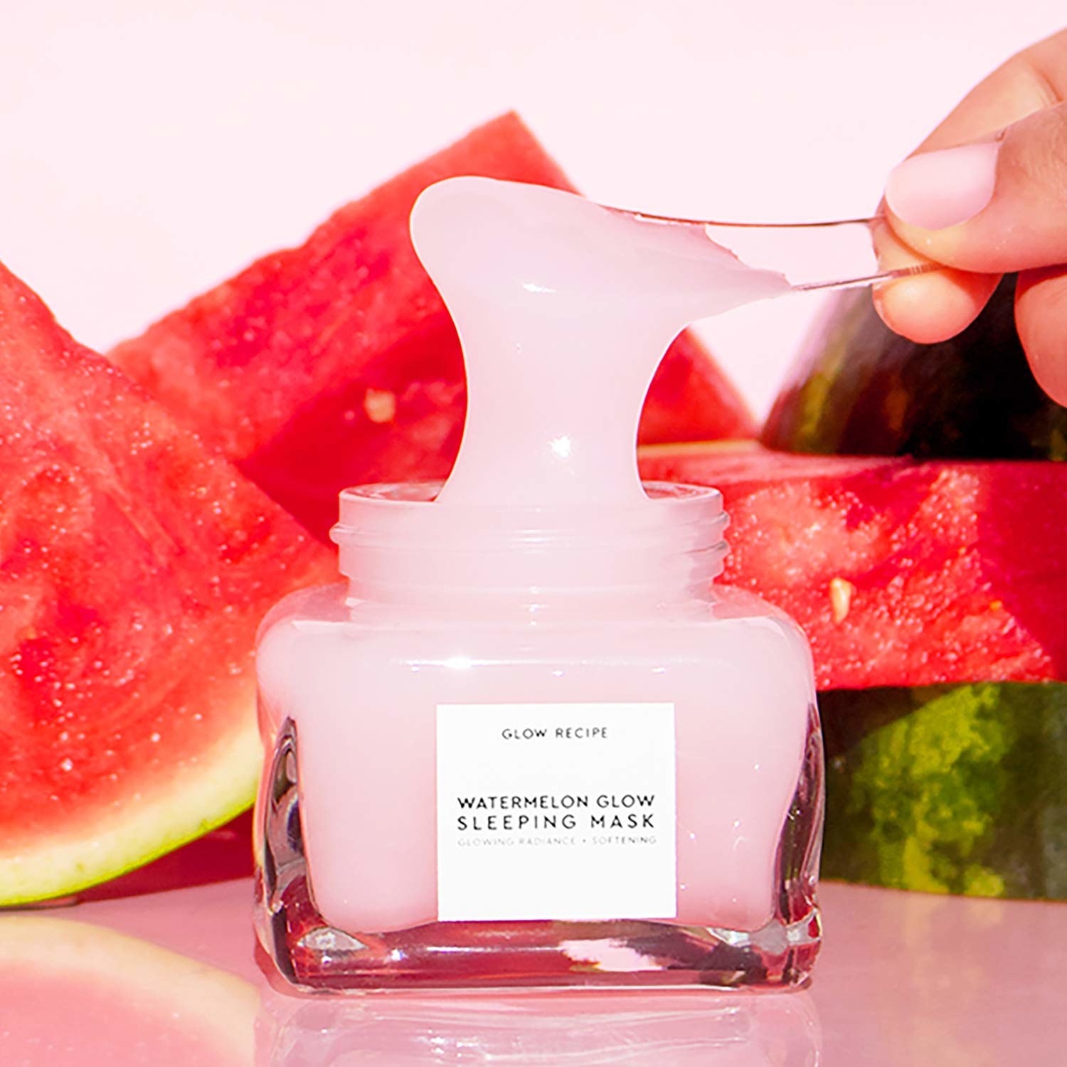 Watermelon Glow Sleeping Mask jar with a model scooping some out