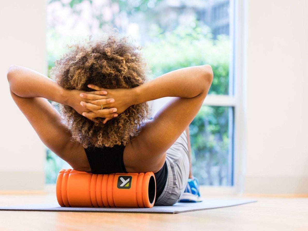 A model using the foam roller on their upper back