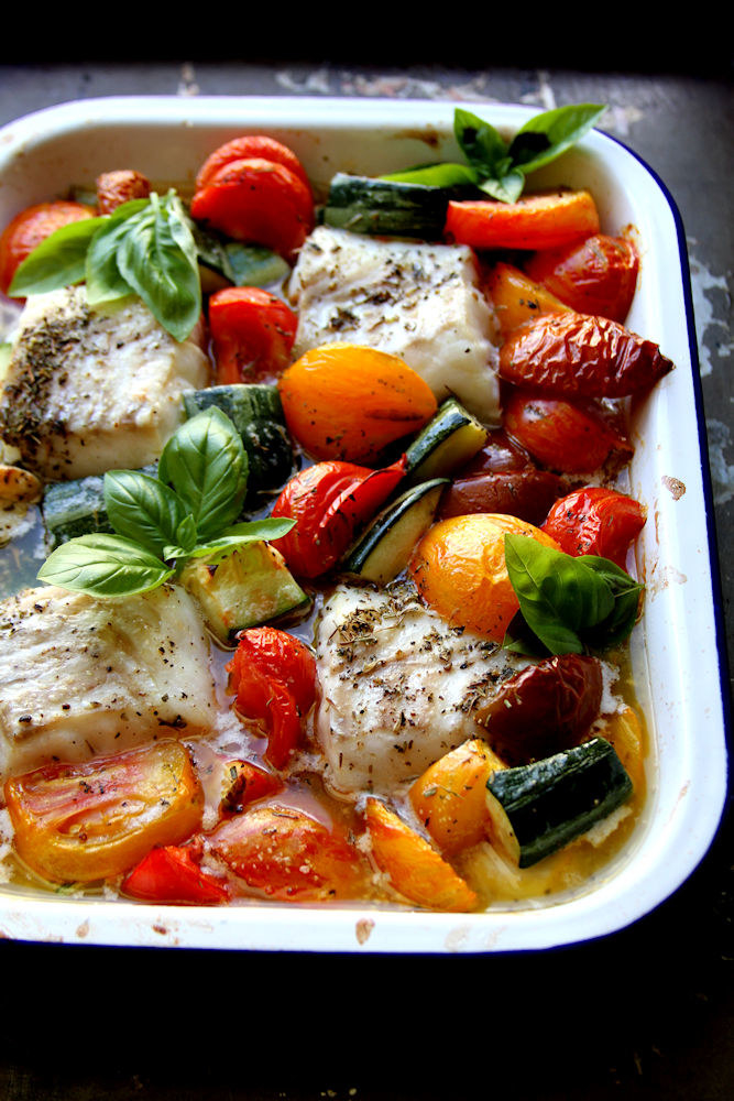 Baked cod with vegetables in a baking dish.