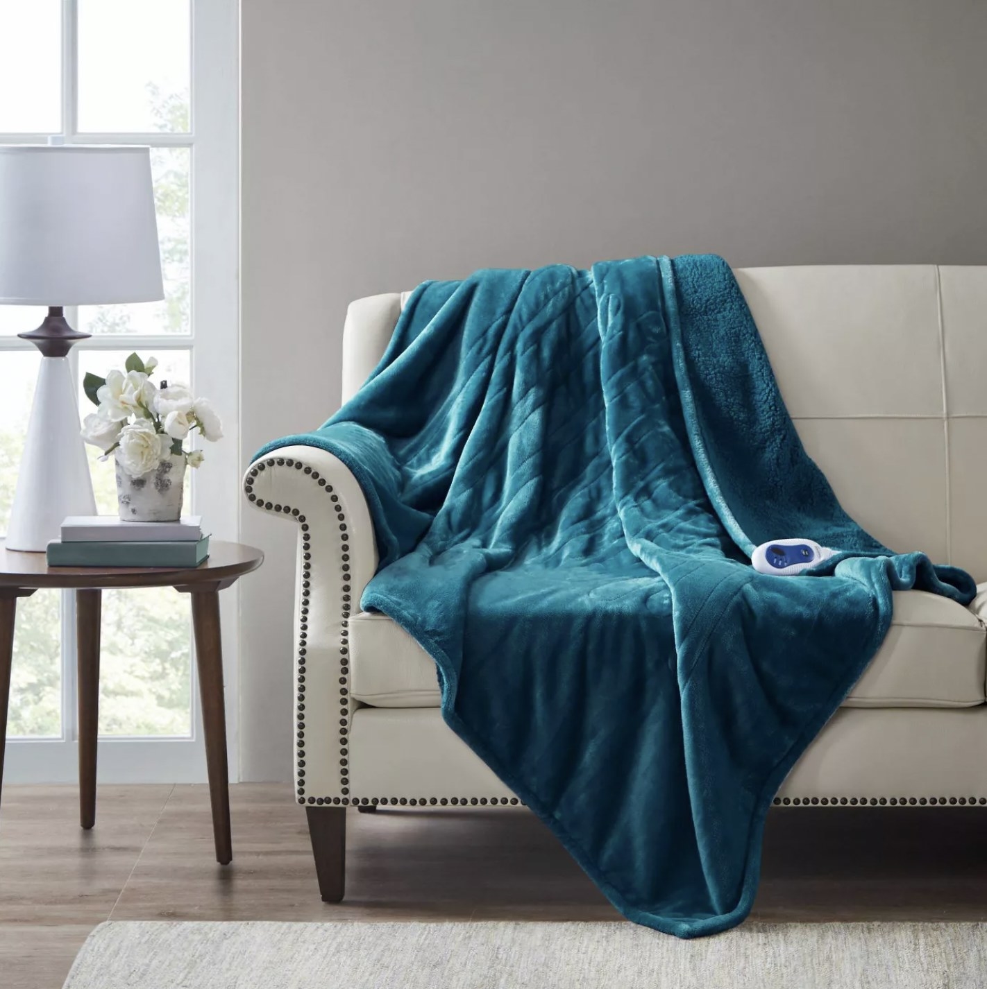 The blue plush throw hanging over the back of a sofa