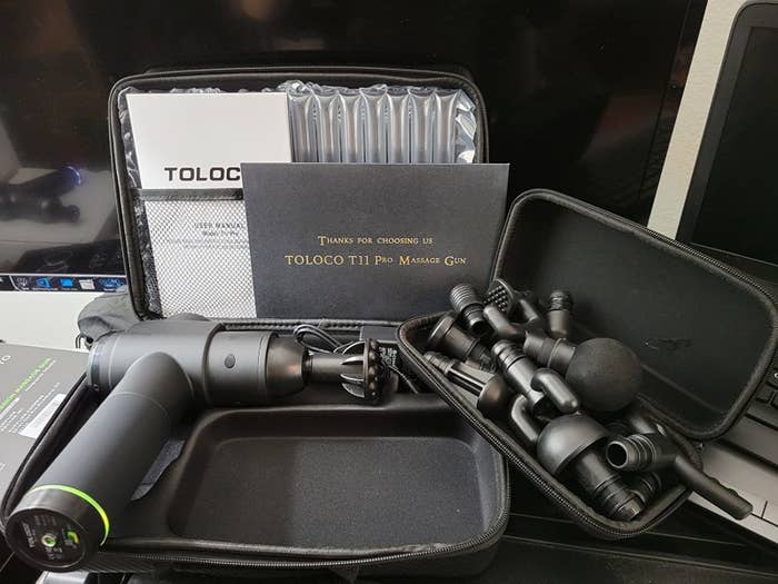 reviewer image of the massage gun and all its accessories in its case