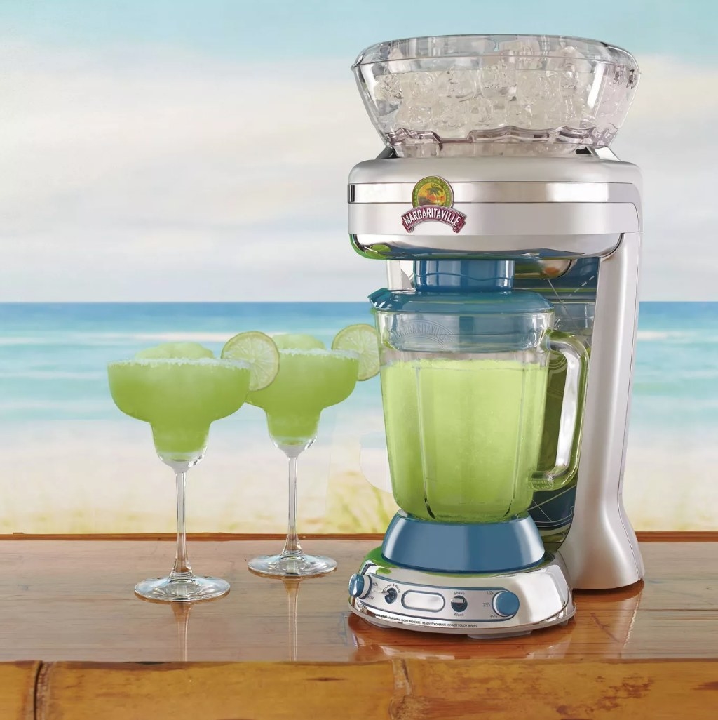 A frozen cocktail machine next to two glasses of margaritas