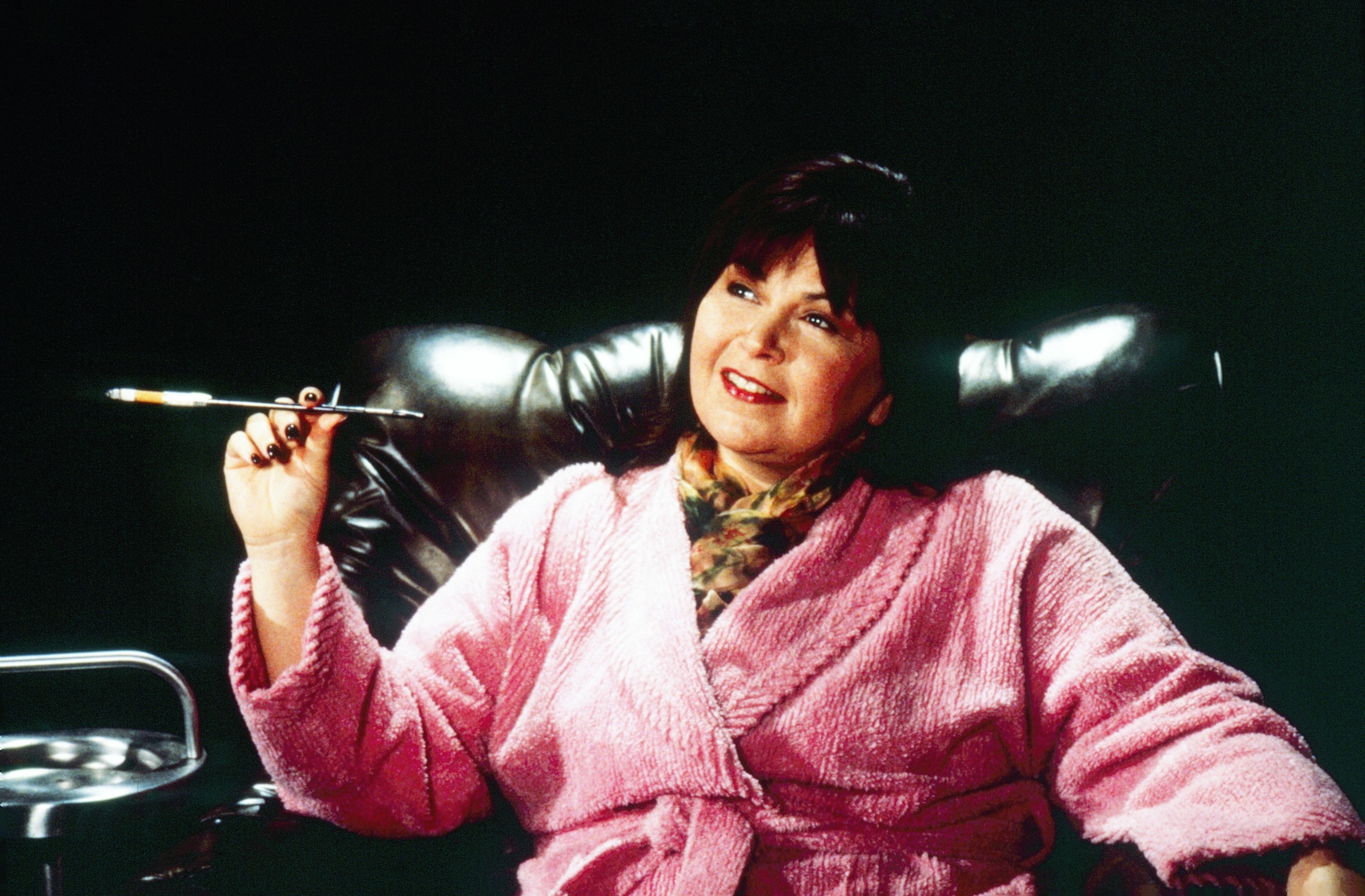Roseanne in the show sitting on a leather chair