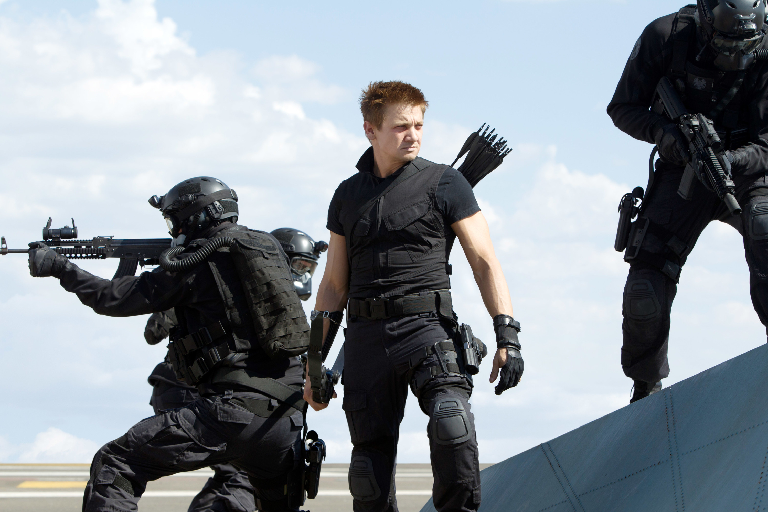 Hawkeye in between to soldiers wielding machine guns