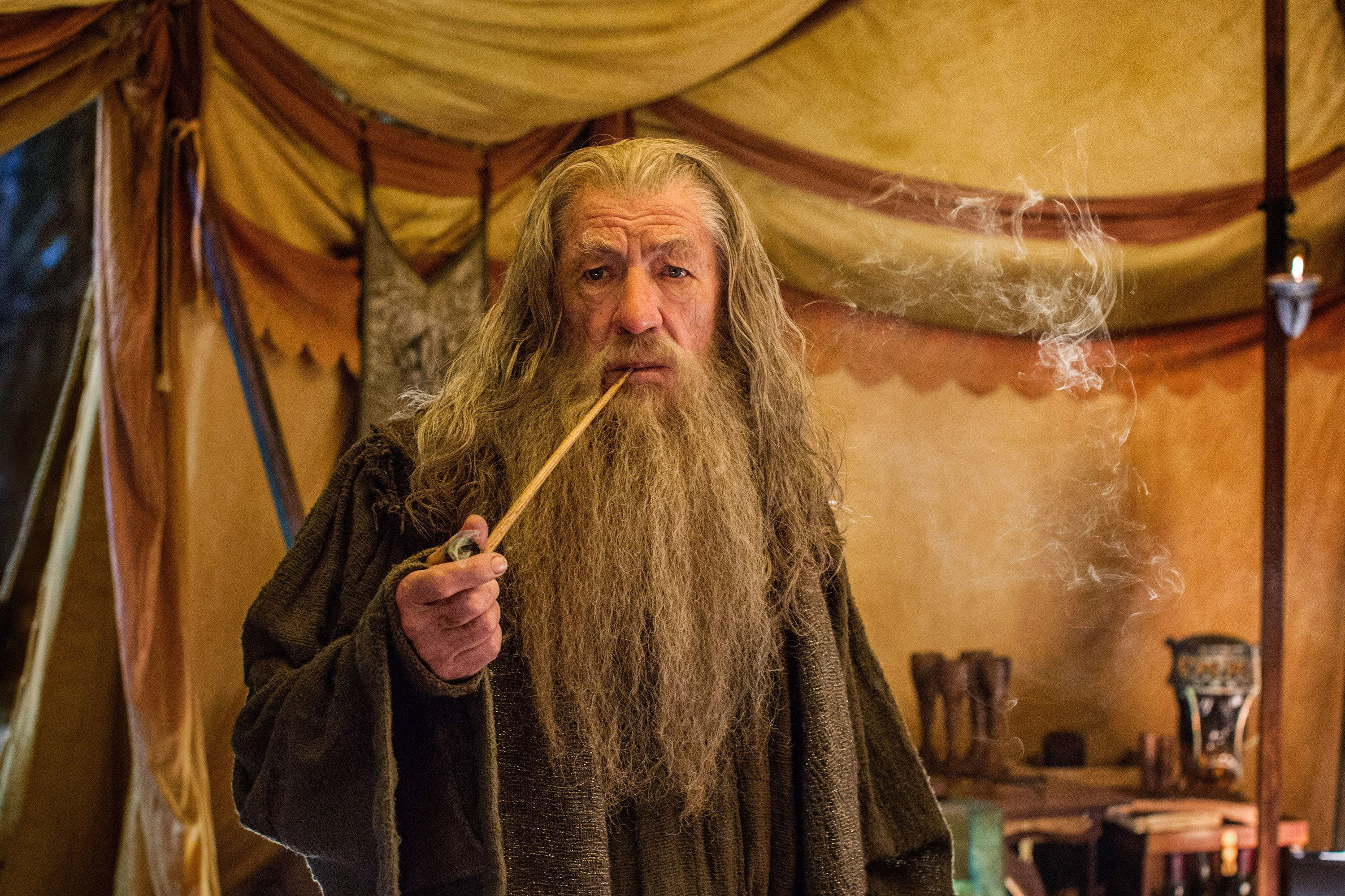 Gandalf smoking a long pipe in a tent