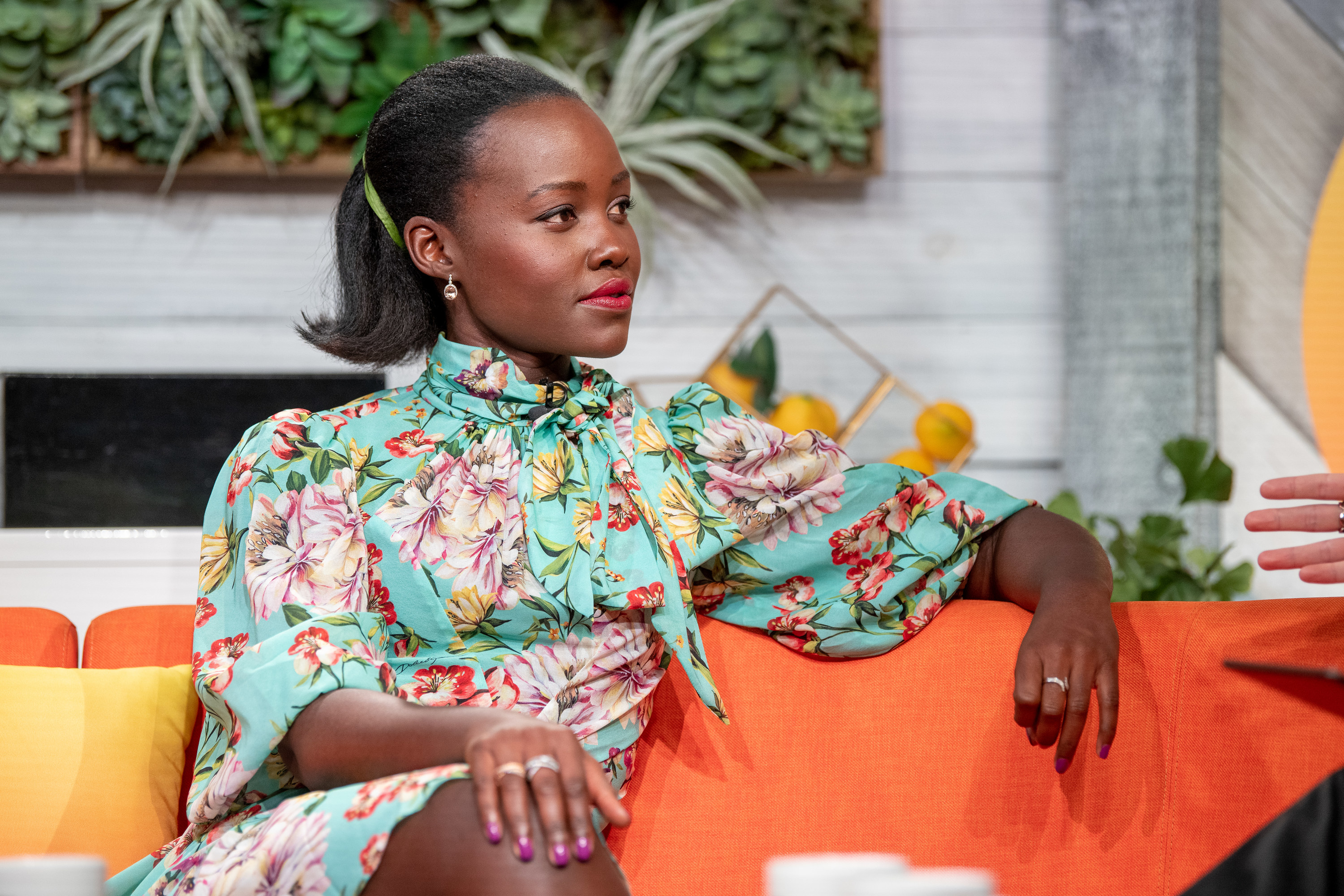 Lupita Nyong&#x27;o sitting on the couch during an interview on BuzzFeed&#x27;s AM To DM show