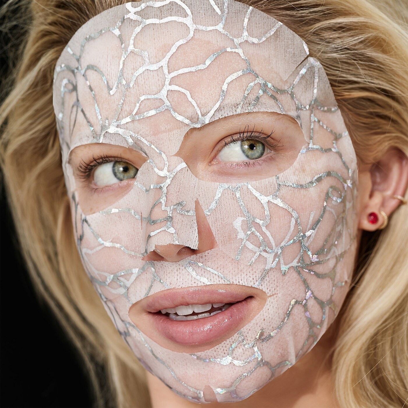 a person wearing the two-piece sheet mask; metallic detailing is visible