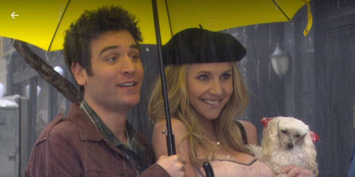 ted holds an umbrella over stella's head, they're both smiling