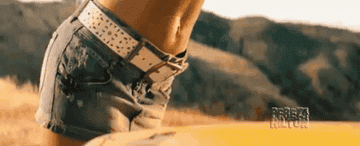 Megan Fox looking under the hood of a car in transformers