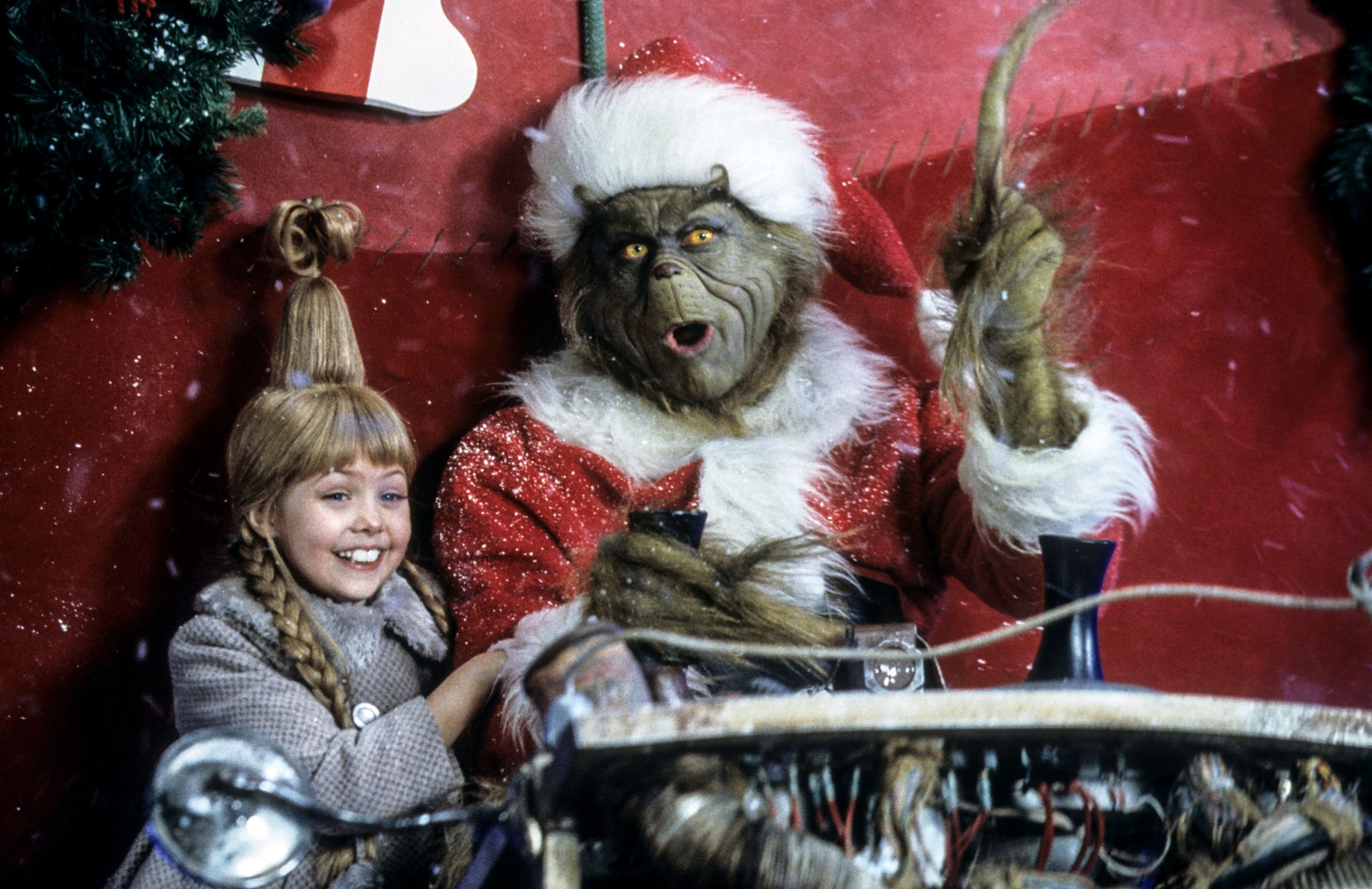the grinch in a sleigh with one of the Whos