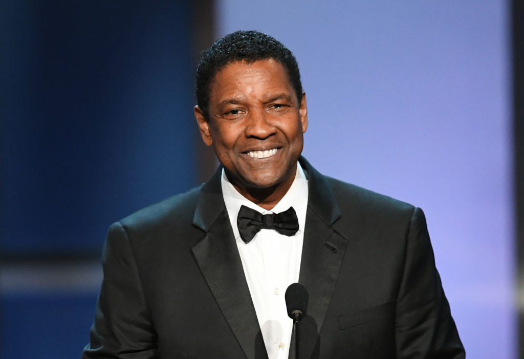Denzel in a tux smiling onstage