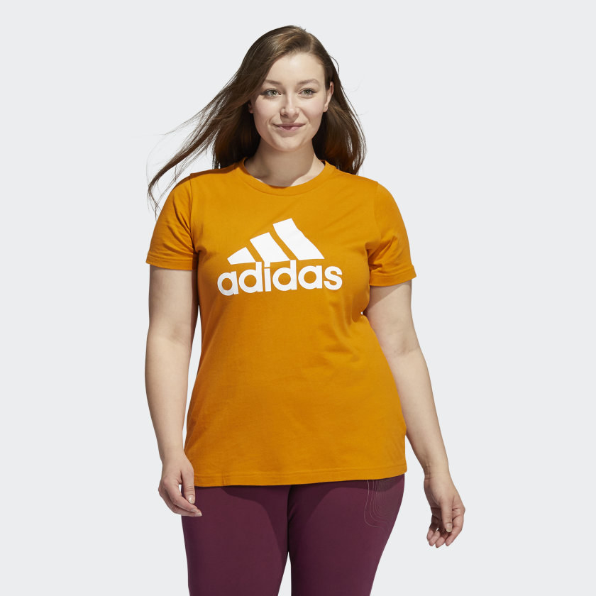 An image of a model wearing a plus-size badge of sport classic tee in orange