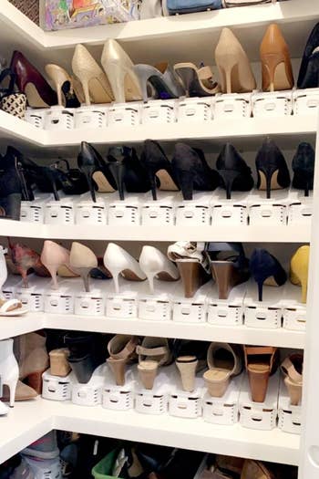 several pairs of heels organized in a closet with the white stackers that allow you to put one shoe on top and one on bottom