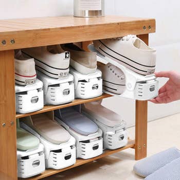 hands organizing sneakers on a shoe rack with the product