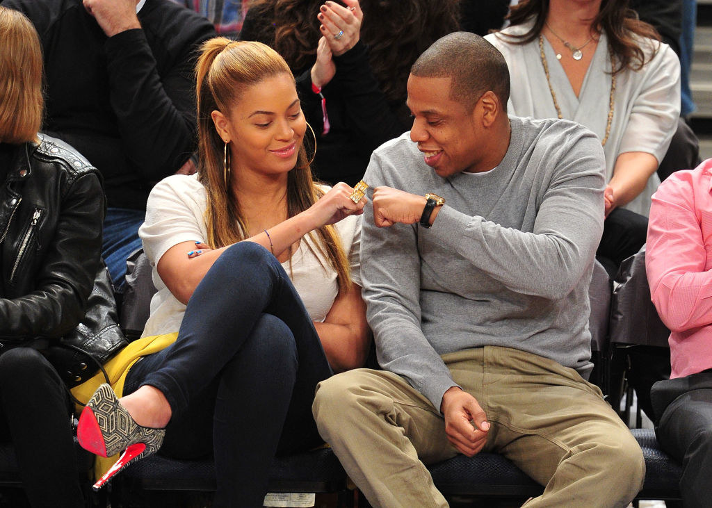the couple is fist bumping at a knicks game
