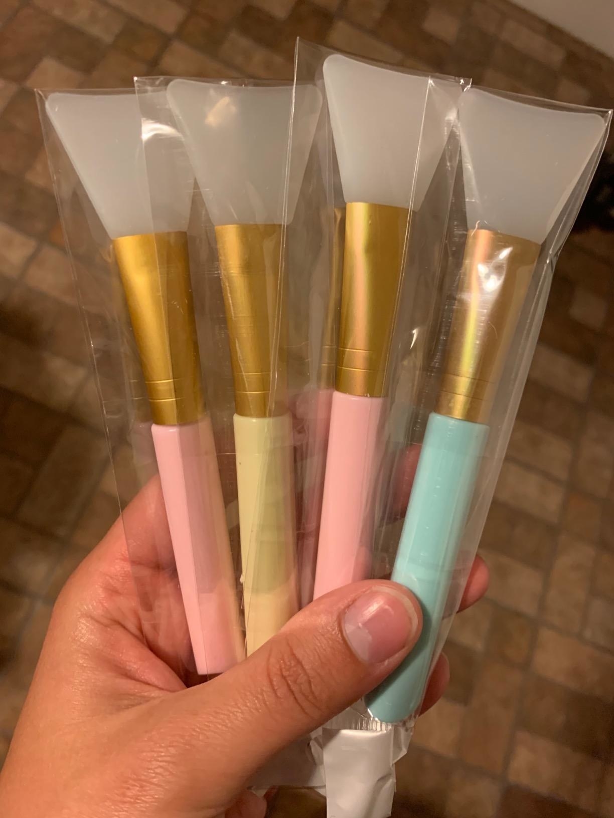 reviewer holding pack of four colorful silicone mask applicators