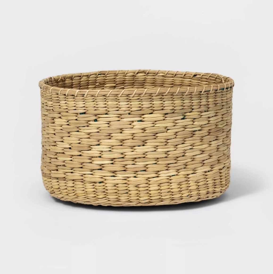 The round woven basket is a light tan color