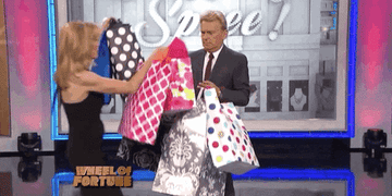 An image of gif of Vanna White handing Wheel of Fortune host Pat Sajak shopping bags