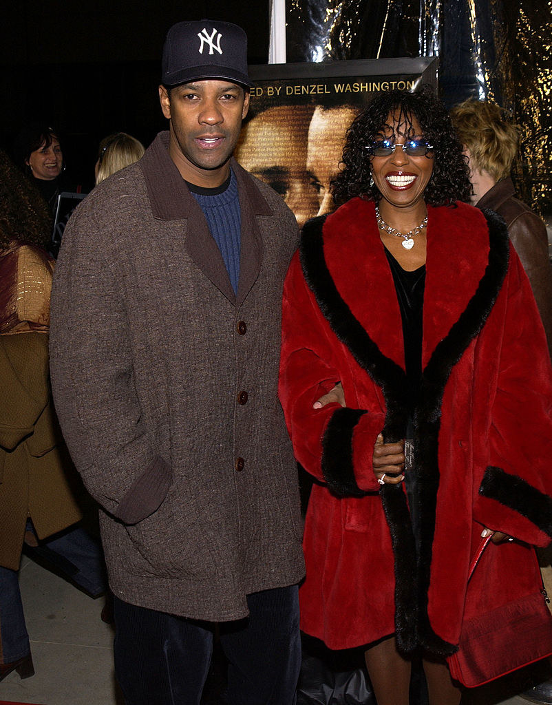 the couple is in big coats on a red carpet