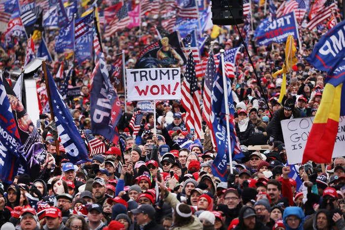 A crowd of Trump supporters with one person holding up a sign that says