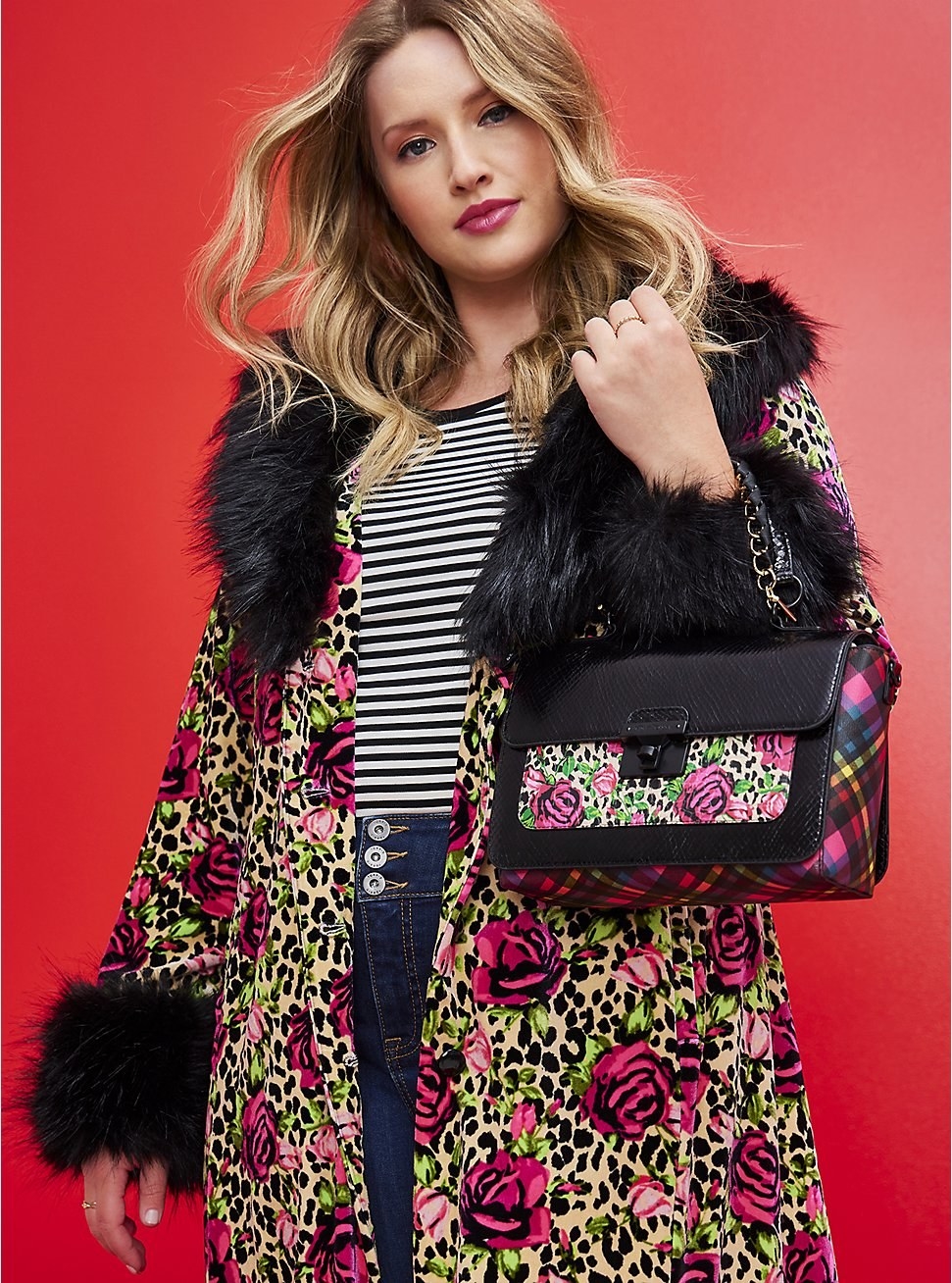 model wearing floral coat and holding floral satchel bag