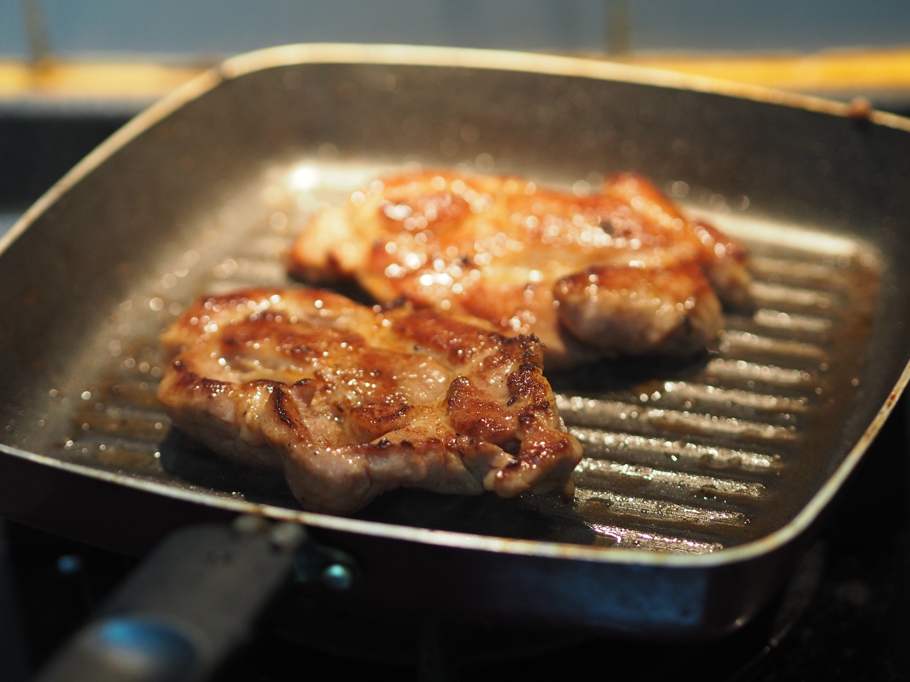 Pork chops cooking in a pan