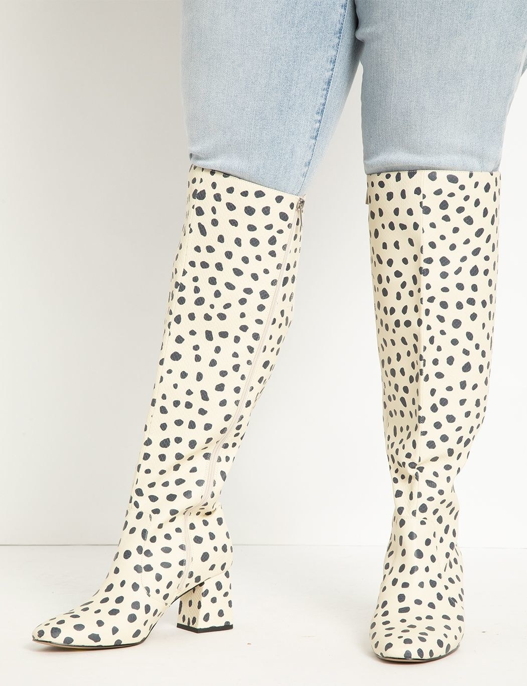 Model wearing white and gray leopard spotted knee-high boots