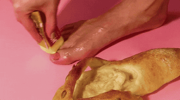Woman washing foot next to a sandal made out of bread?