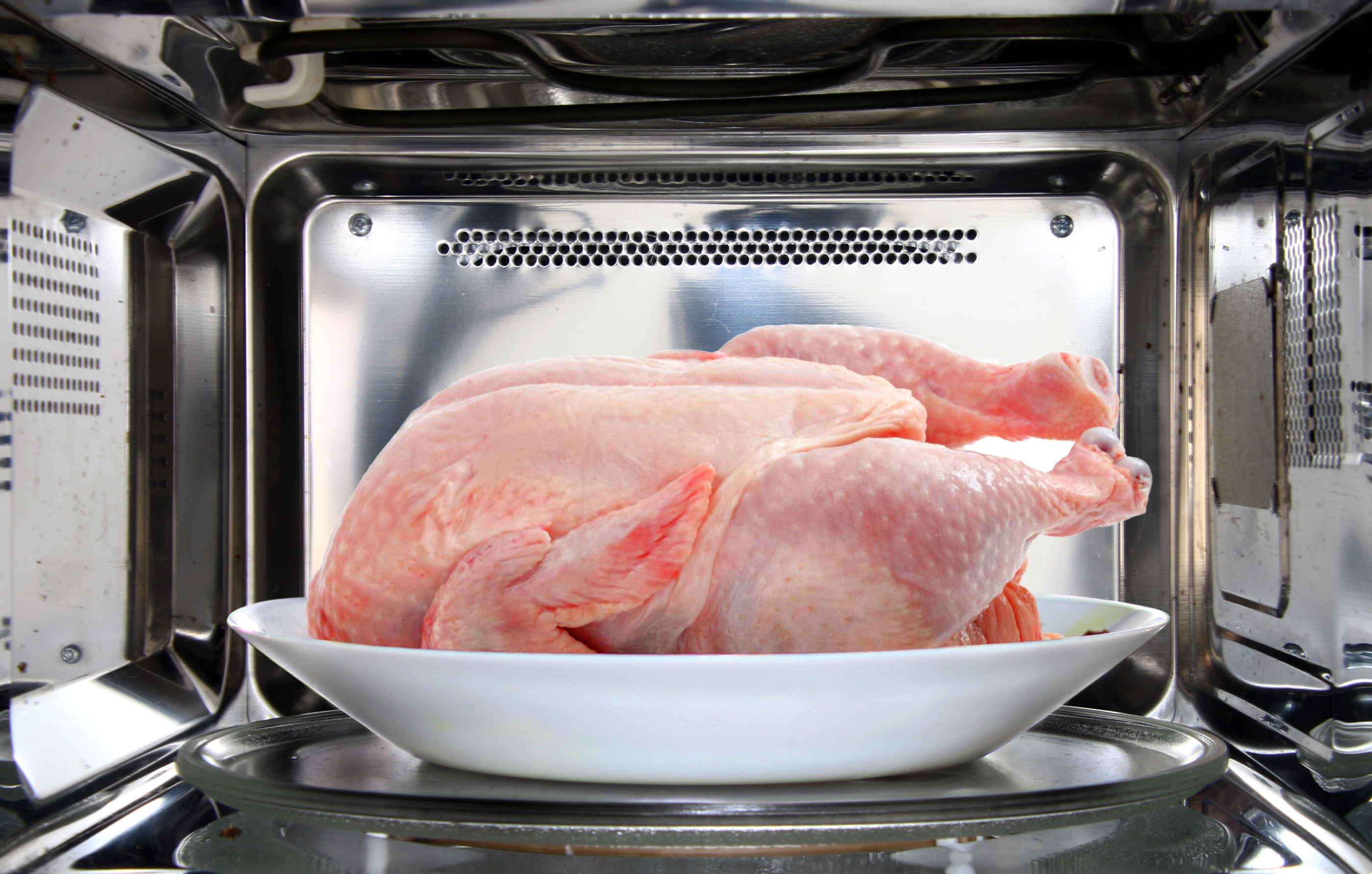 Whole chicken defrosting in the microwave