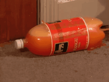 Orange soda spraying out of a bottle