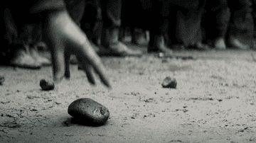 Villagers throw rocks at Geralt