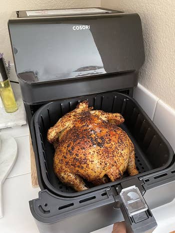 a different reviewer showing a cooked chicken in the black air fryer
