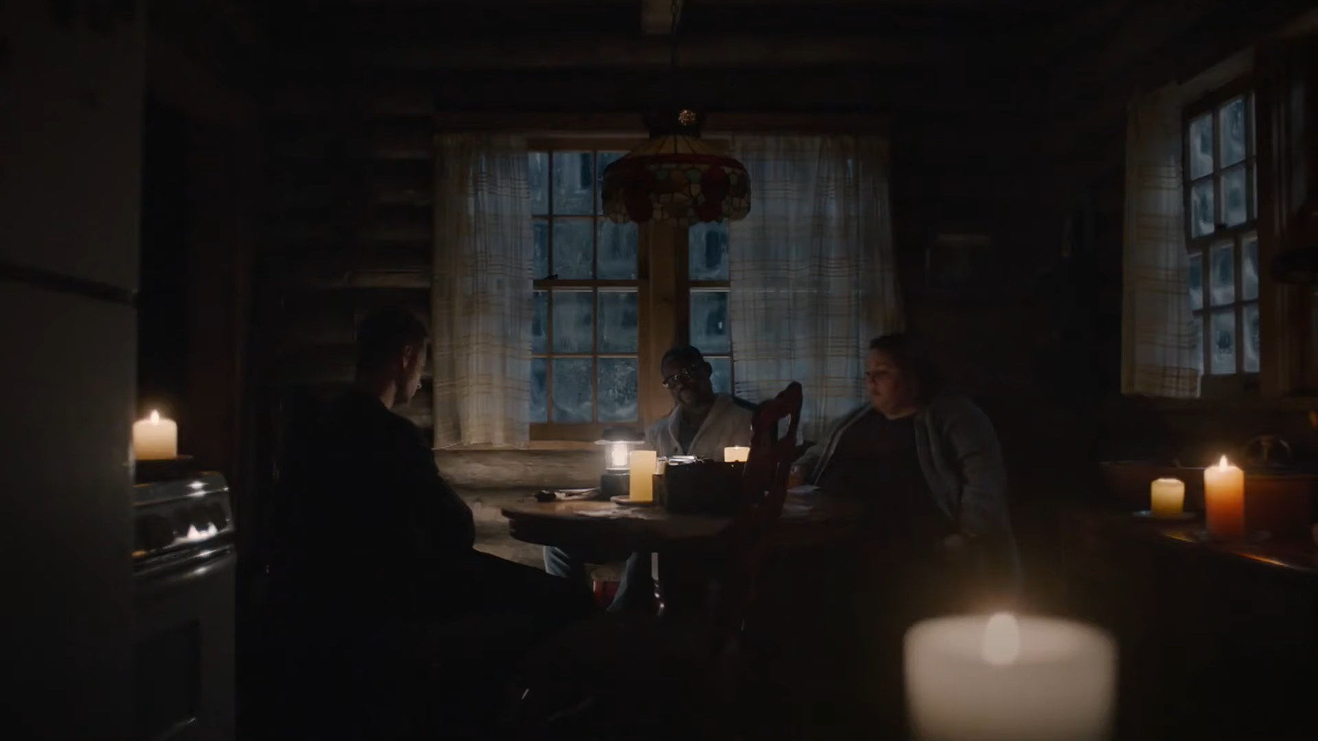 Wide shot of Kevin, Kate, and Randall as adults sitting at a cabin table