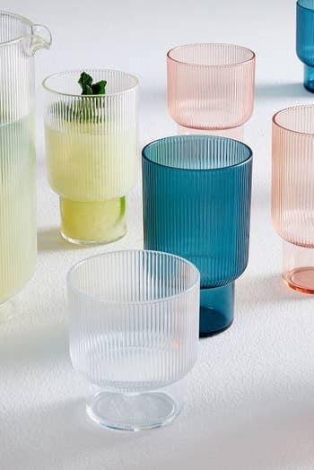 clear, blue, and pink acrylic glasses spread out on a table