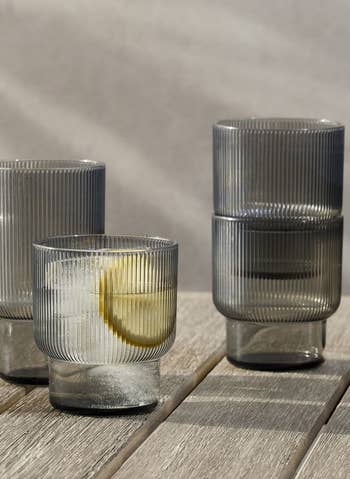 The gray glasses filled with water, and two stacked behind