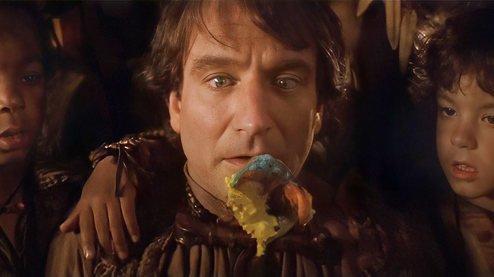 Robin Williams as Peter Pan staring hungrily at a spoon with imaginary food all over it