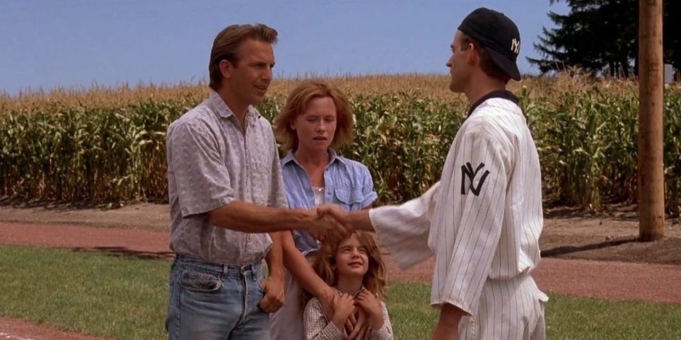 A baseball player shaking a man&#x27;s hand in front of his family.