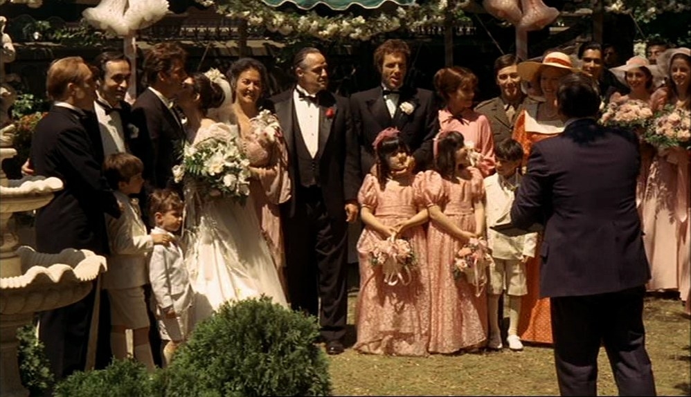 A large family gathered at a wedding, getting their photo taken.