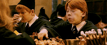 Ron getting a scare as he picks up a chicken drumstick and Nearly Headless-Nick appears from the plate