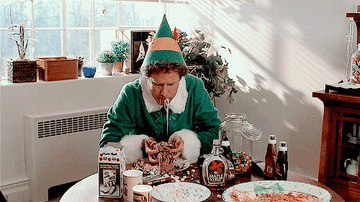 Will Ferell as Buddy the Elf stuffing handfuls of syrup and candy covered spaghetti into his mouth