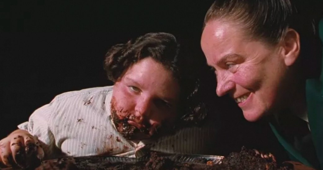 Pam Ferris as Miss Trunchball glaring at a very sick looking Bruce Bogtrotter who has cake all over his face