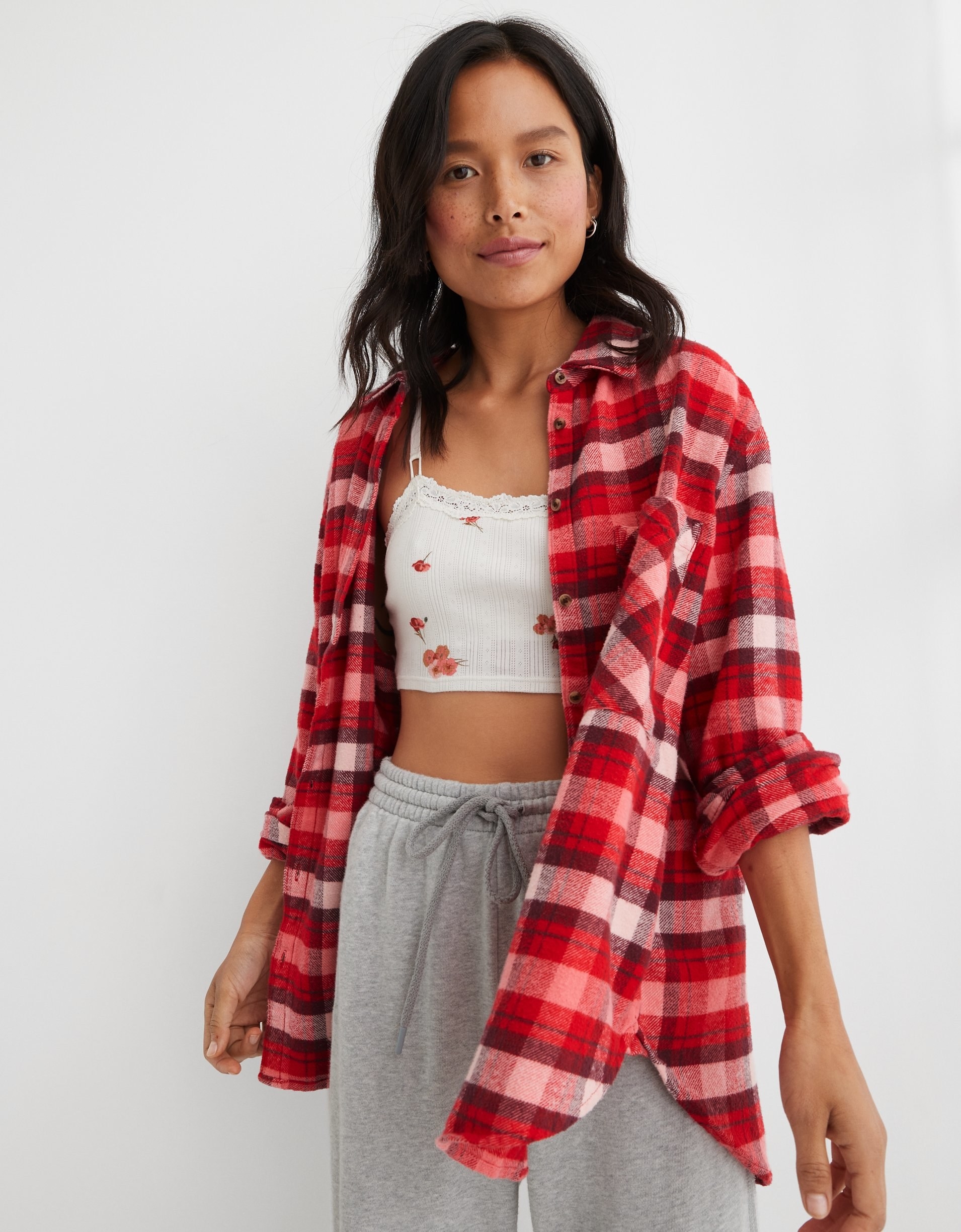 model in red plaid flannel open button-up over a bralette