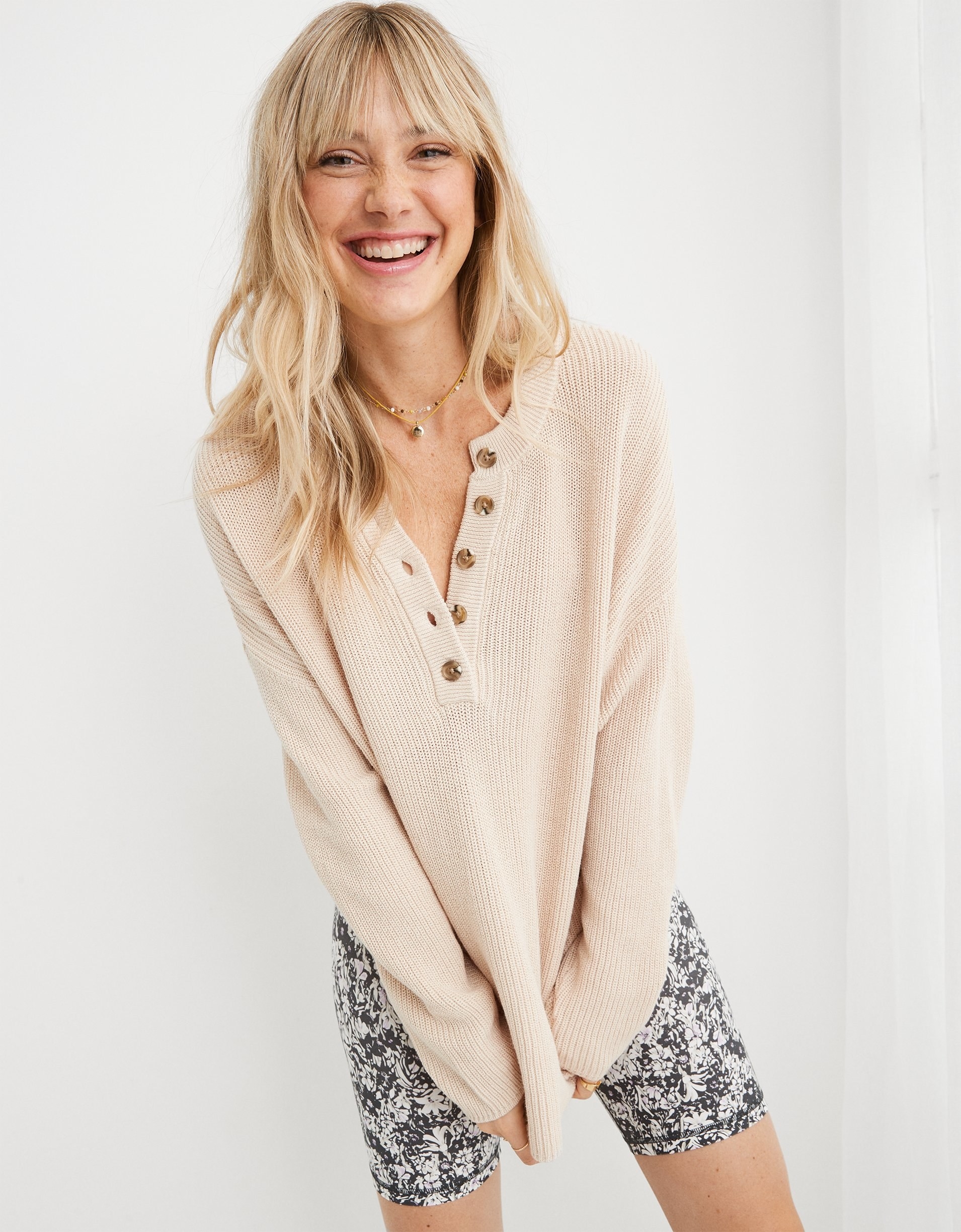 model in beige henley long sleeve sweater with tortoise shell buttons