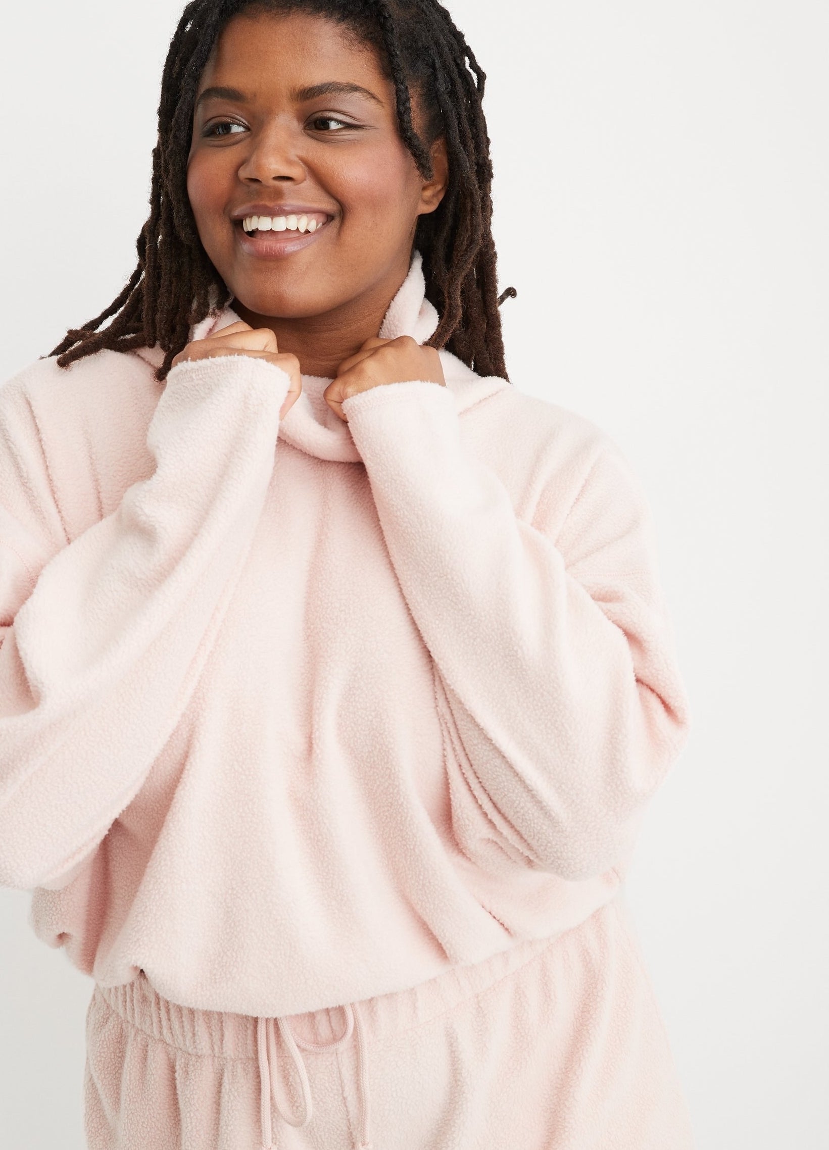 model in the fleece turtleneck in light pink