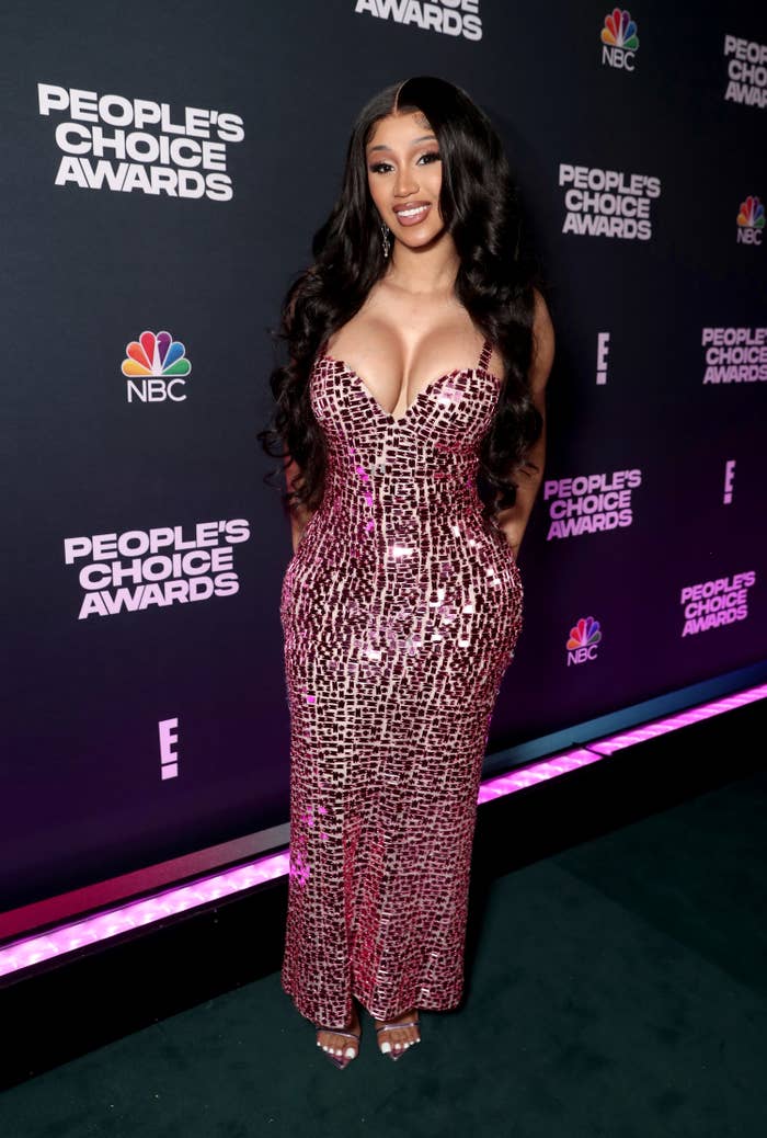 Cardi posing on the red carpet of the People&#x27;s Choice Awards in a sequined dress with a sweetheart neckline
