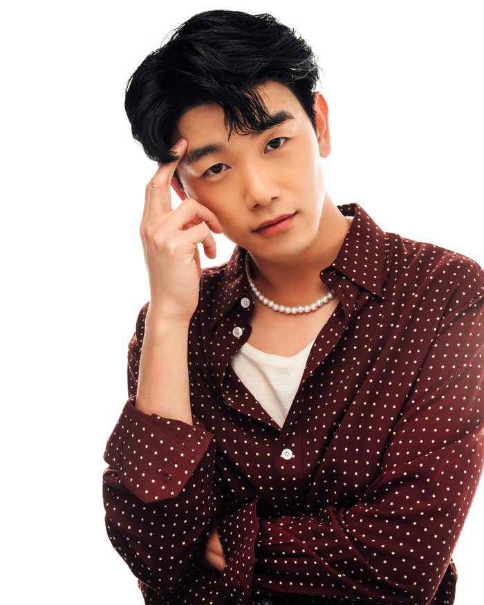 Eric wearing a polka dot shirt as he poses for a photo with his hand on his head