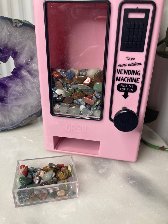 pink plastic vending machine full of small crystals