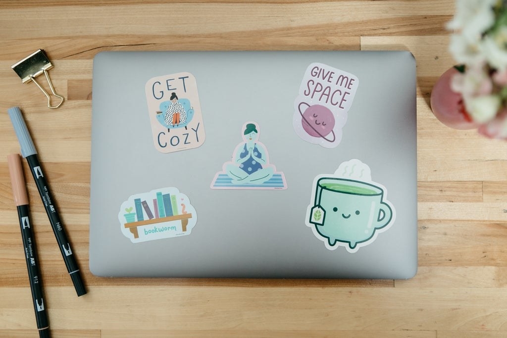 a laptop with an array of cozy stickers on it